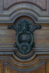 The old door knocker on a wooden door