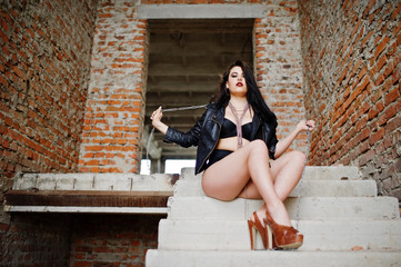 Brunette plus size sexy woman, wear at black leather jacket, lace panties, bra and high heels with...