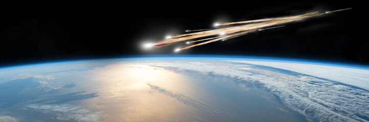A meteor streaks towards a collision with Earth as it breaks up over the ocean.  Clouds cover an ocean area of the planet. - 165802400