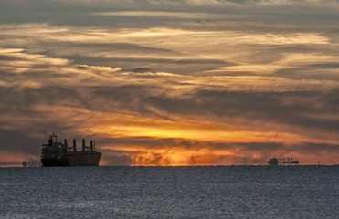 Fototapeta na wymiar Mystical sunset on the Baltic Sea. The water area of the port of Klaipeda, Lithuania