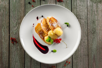 Delicious toasts with fruit jam and custard on a plate. Healthy European breakfast on a rustic wooden table. Top view.