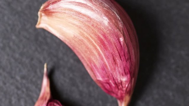 Slowly panning over fresh ripe garlic bulbs on a slate surface