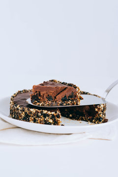 Useful chocolate raw tart with nuts, a piece of tart.