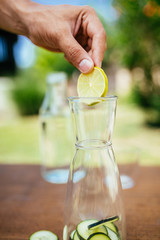Placing Lemon In The Glass Bottle