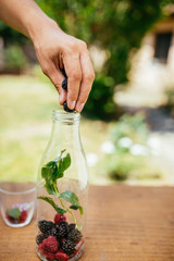 Placing Blackberry In Glass Bottle