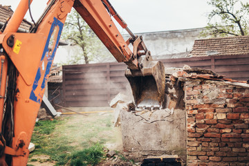  bulldozer crushing an old building at construction site