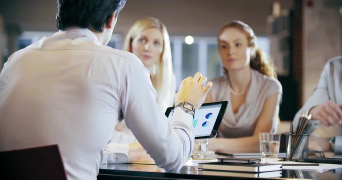 Corporate business team work office meeting.Four caucasian businessman and businesswoman people group talking strategy together.Collaboration,growing,success concept using tablet and chart. 4k video