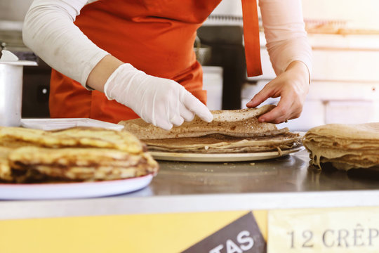 femme pr&eacute;parant des cr&ecirc;pes dans camion, street food