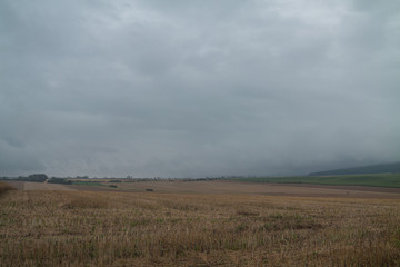 Fototapeta premium Regenwolken über geerntetem Feld