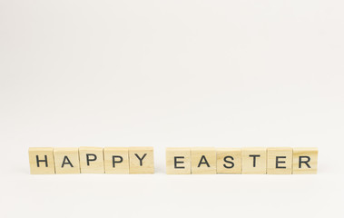 Text wooden blocks spelling the word happy easter on white background