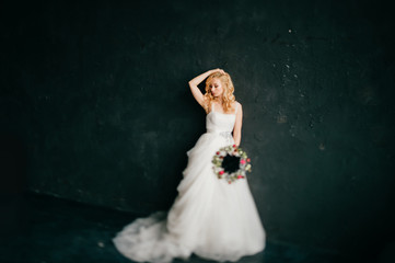 Young beautiful happy glamorous bride in white expensive stylish weding dress posing for camera. Marriage photosession. Isolated on black. Blonde cute angel doll girl in studio.  Future wife portrait.