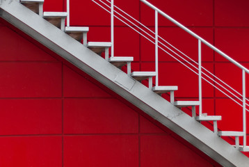gray metal stair on the red wall.