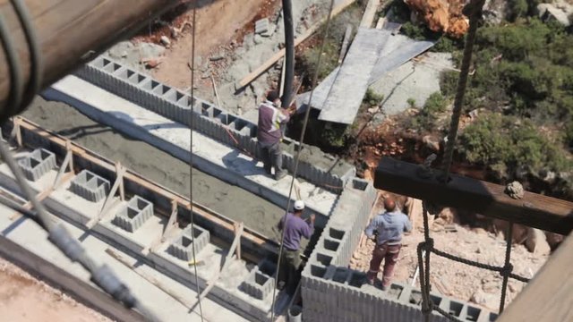 High angle view of construction workers pouring concrete in construction site
