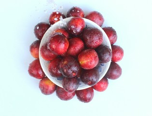 Plums on a plate and on a table