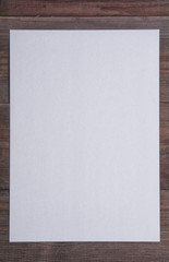 Fototapeta premium empty sheet of paper on dark wooden desk