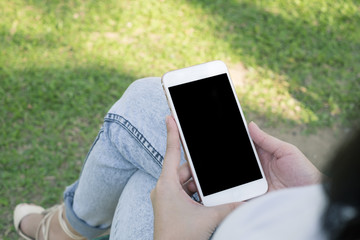 Woman using cellphone in public park.