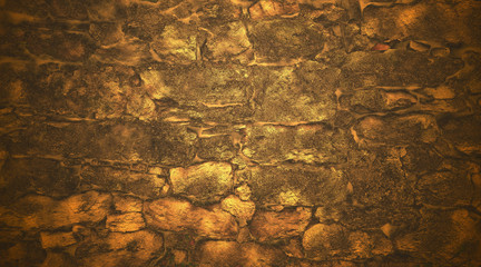 Old masonry of irregularly shaped stones illuminated by soft golden light