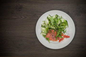 Meat of trout on a plate with vegetables and grapefruit