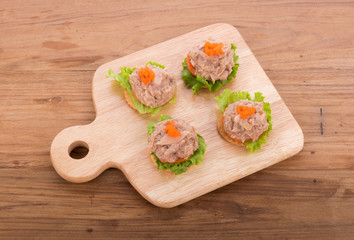 tuna salad with cracker on wooden background