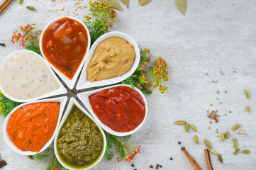 A tasty assortment of sauces in a form of flower with spices and herbs.