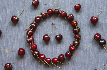 Creative layout made cherries on gray textile background. Round frame. Flat lay. Top view. Summer concept.