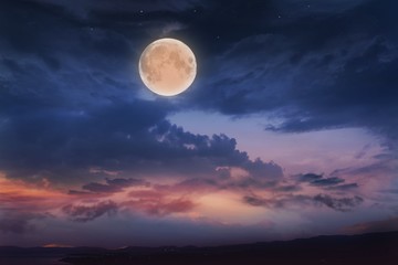 Glowing sunset and full moon  . Beautiful cloudy sky. Cloudy abstract background. Sunset colors. 