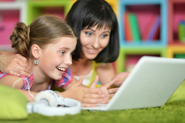 mother and daughter using laptop