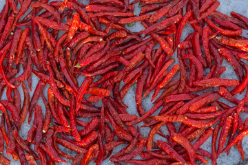 Pile of dried red chili peppers background, top view.
