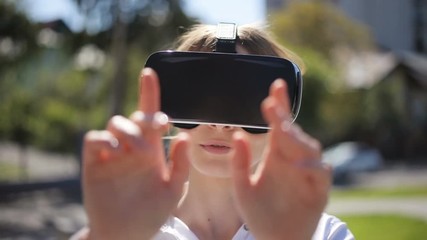 woman getting experience using virtual reality glasses VR headset outside 3d cyberspace gesturing full face hands gentle moving touching object closeup nice unfocused smiling smile girl portrait sunny