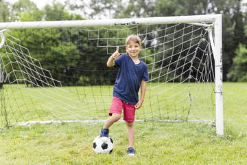 Young Boy with football on a field having fun