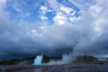 Iceland - Turquoise hot boiling water, begin of eruption of geyser strokkur
