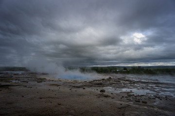 Iceland - Turquoise hot boiling water, before eruption of geyser strokkur with trees