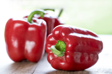 Sweet red peppers on a wooden table. Close up. 