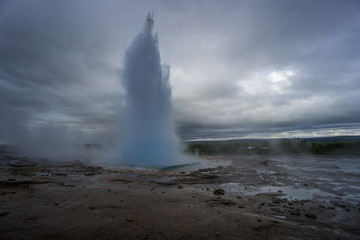 Iceland - Turquoise hot boiling water, end of eruption of geyser strokkur with trees