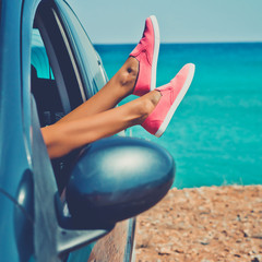 Female legs from the window of car