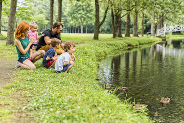 Families with children close to a waterscape with duck on it