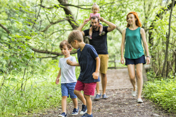 Fototapeta premium Happy young family walking outside in green nature