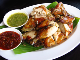 Grilled chicken with sauce in white plate on white plate and black background
