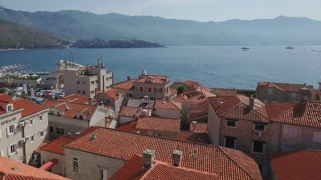 Flying above old town of Budva Montenegro towards city beach, Budva Marina and Adriatic sea with Dukley Zavala on background. Aerial footage.