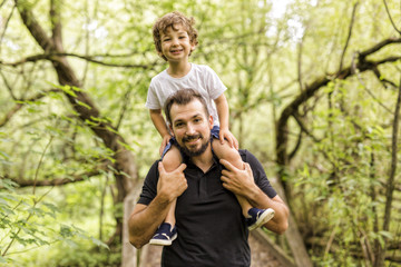 Father and son in forest on a meadow
