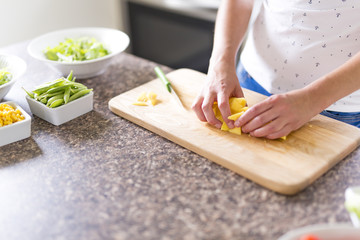 Gorgeous woman doing a salad in her kitchen