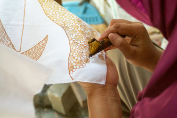 indonesian woman making batik design with wax