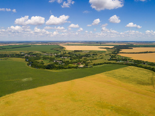 Fototapeta na wymiar view from the air to the village, surrounded by fields and river