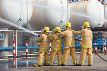 Obraz premium Firefighters spray water in LPG gas tanks, Fire extinguishers caused by explosive gas