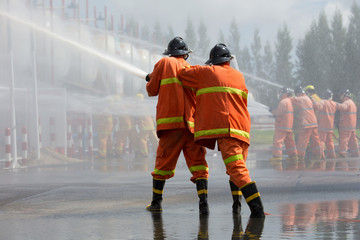 Obraz premium Firefighters spray water in fire extinguishers caused by explosive gas