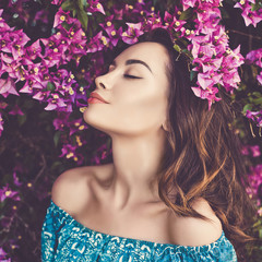 Beautiful young woman surrounded by flowers