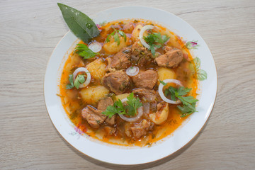 Delicious veal stew soup with meat and vegetables on wood table