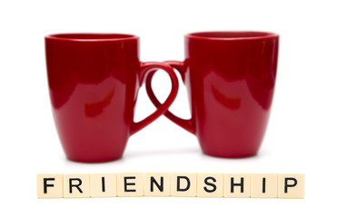Friendship Spelled out in Tiles with Two Coffee Mugs