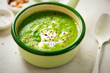 Broccoli spinach pea cream soup with cream and chilli flakes 