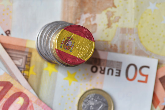 euro coin with national flag of spain on the euro money banknotes background